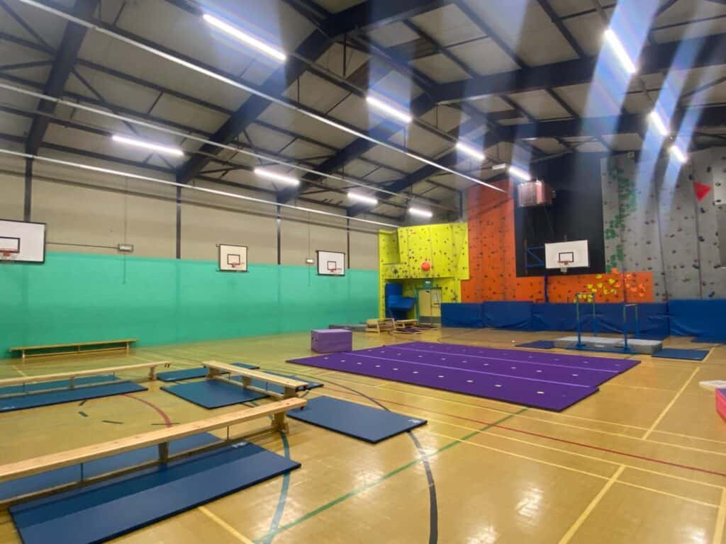 A1. Indoor sports hall with climbing wall, trampolines, and basketball hoops, suitable for various recreational activities and training sessions.