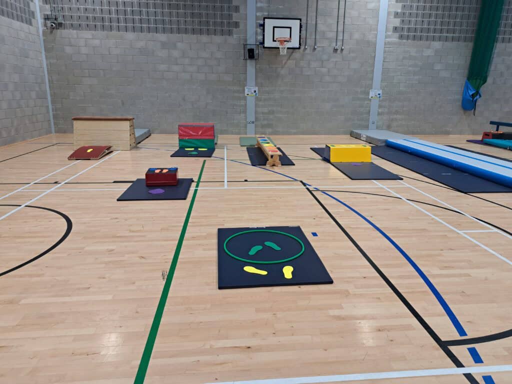 Obstacle course equipment set up on a gymnasium floor for physical activity and training.