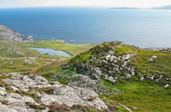 Spectacular Hebridean coast with rugged cliffs and rolling green hills, perfect for island adventures.