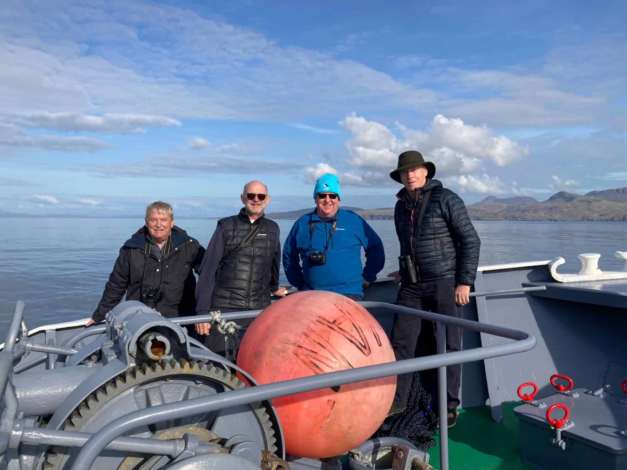 Group of travelers on a boat with scenic island views and calm waters in the background.