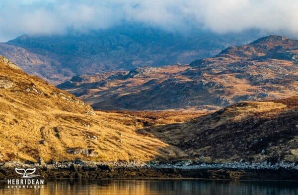 Stunning Hebrides landscape with rolling hills and mountain views.