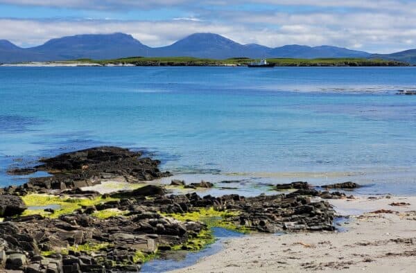 Scenic coastal landscape with turquoise waters and rugged shoreline in the Hebrides.