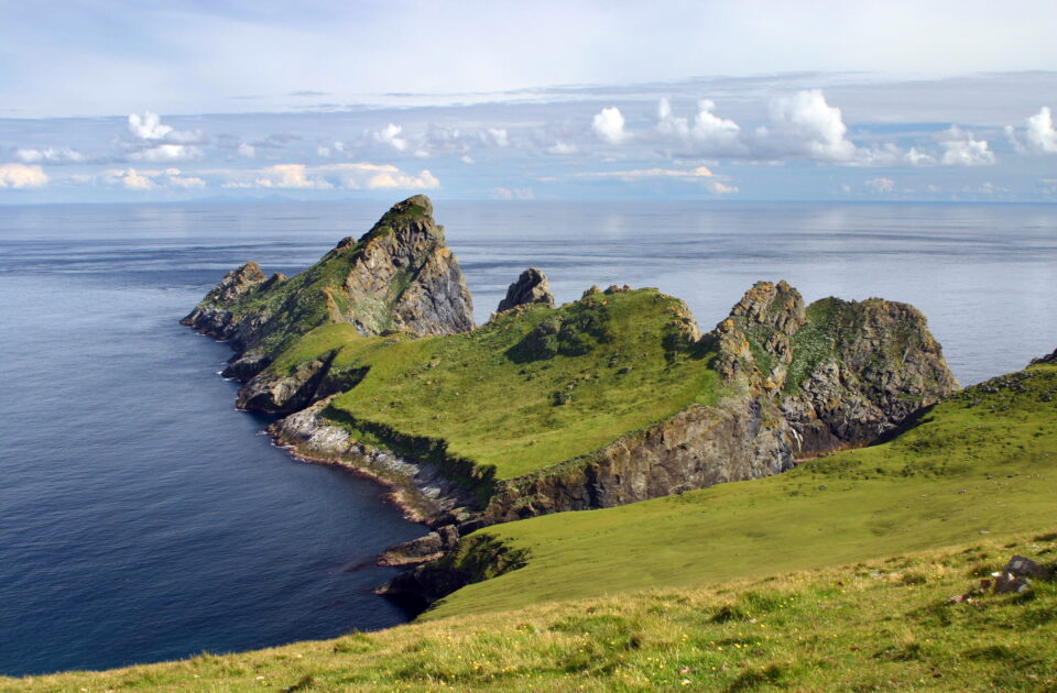 Spectacular Scottish seaside landscape featuring rugged cliffs and vibrant greenery on the Isle of Skye.