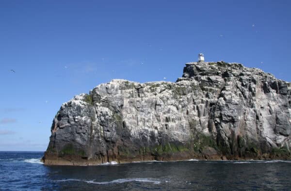 Seaside cliffs with lighthouse in Hebrides, home to seabirds and stunning ocean views. Perfect for adventure and nature lovers.
