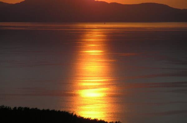 Breathtaking sunset with vibrant colours reflecting on the water around the Hebrides.