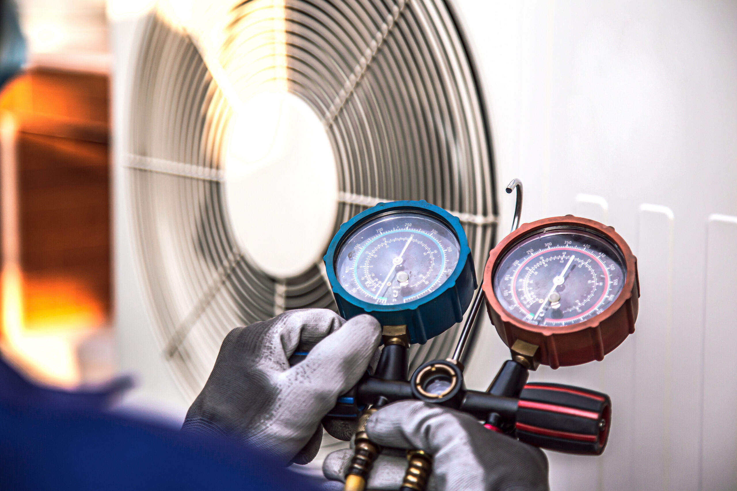 HVAC technician checking pressure gauges on heating system.