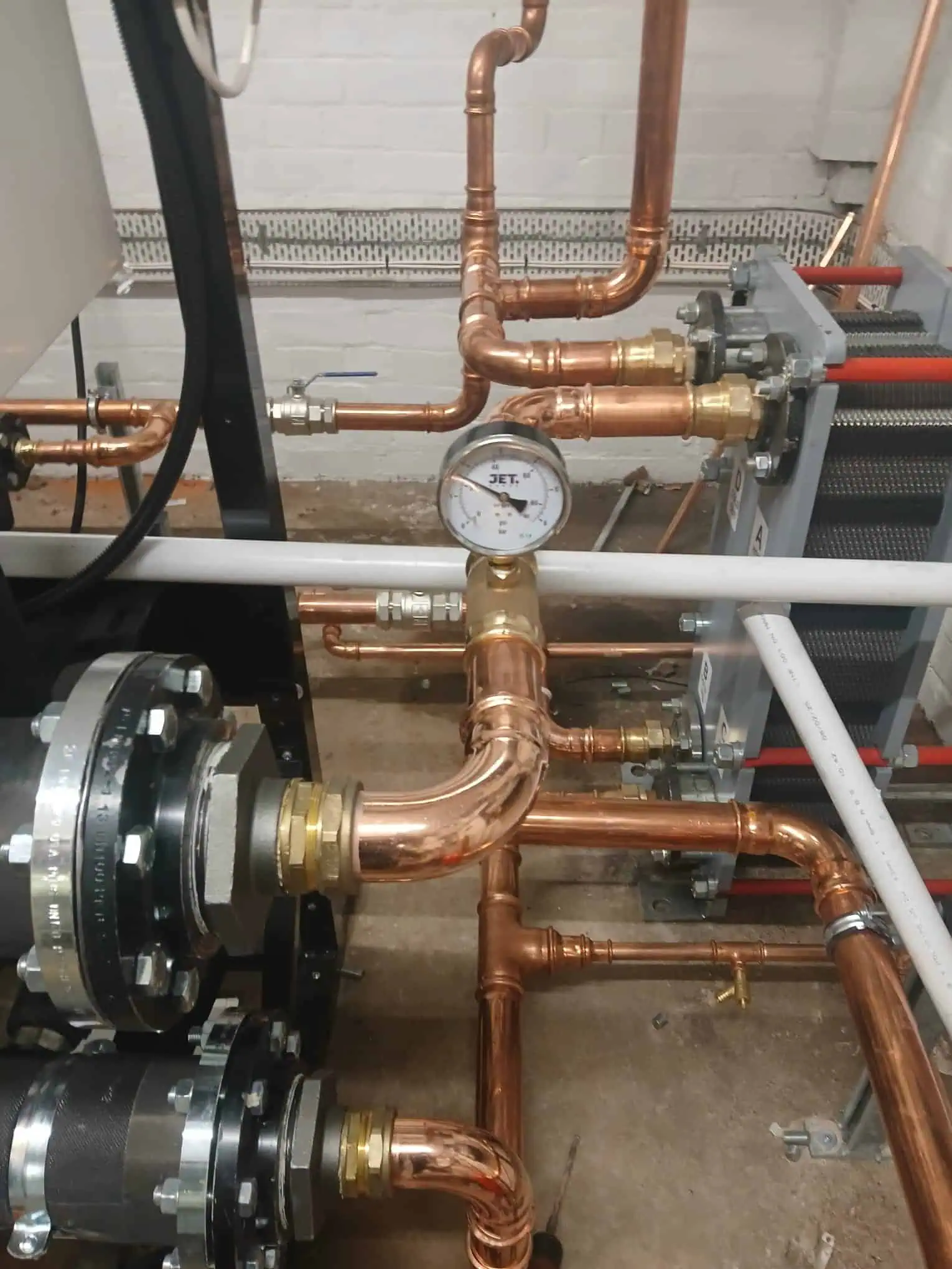Industrial plumbing system with copper pipes and pressure gauge at Halesowen Gas Services.