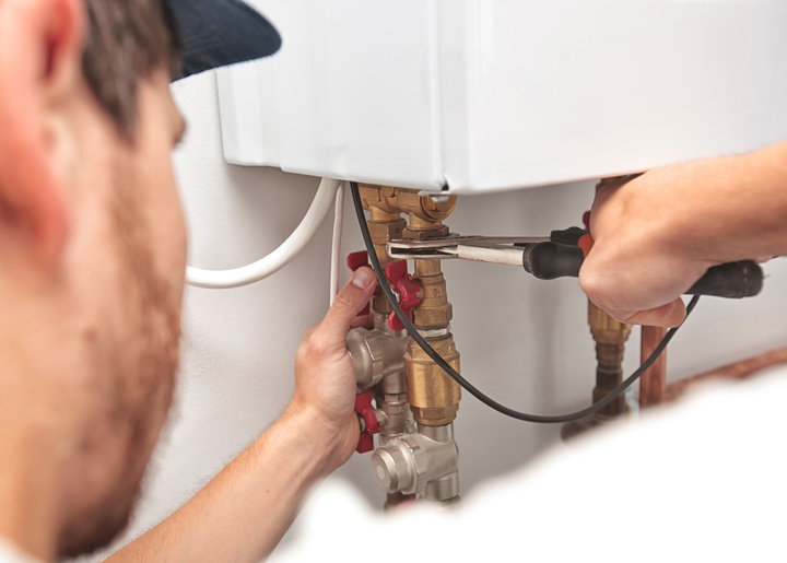Gas technician repairing or installing gas pipes and boiler system.