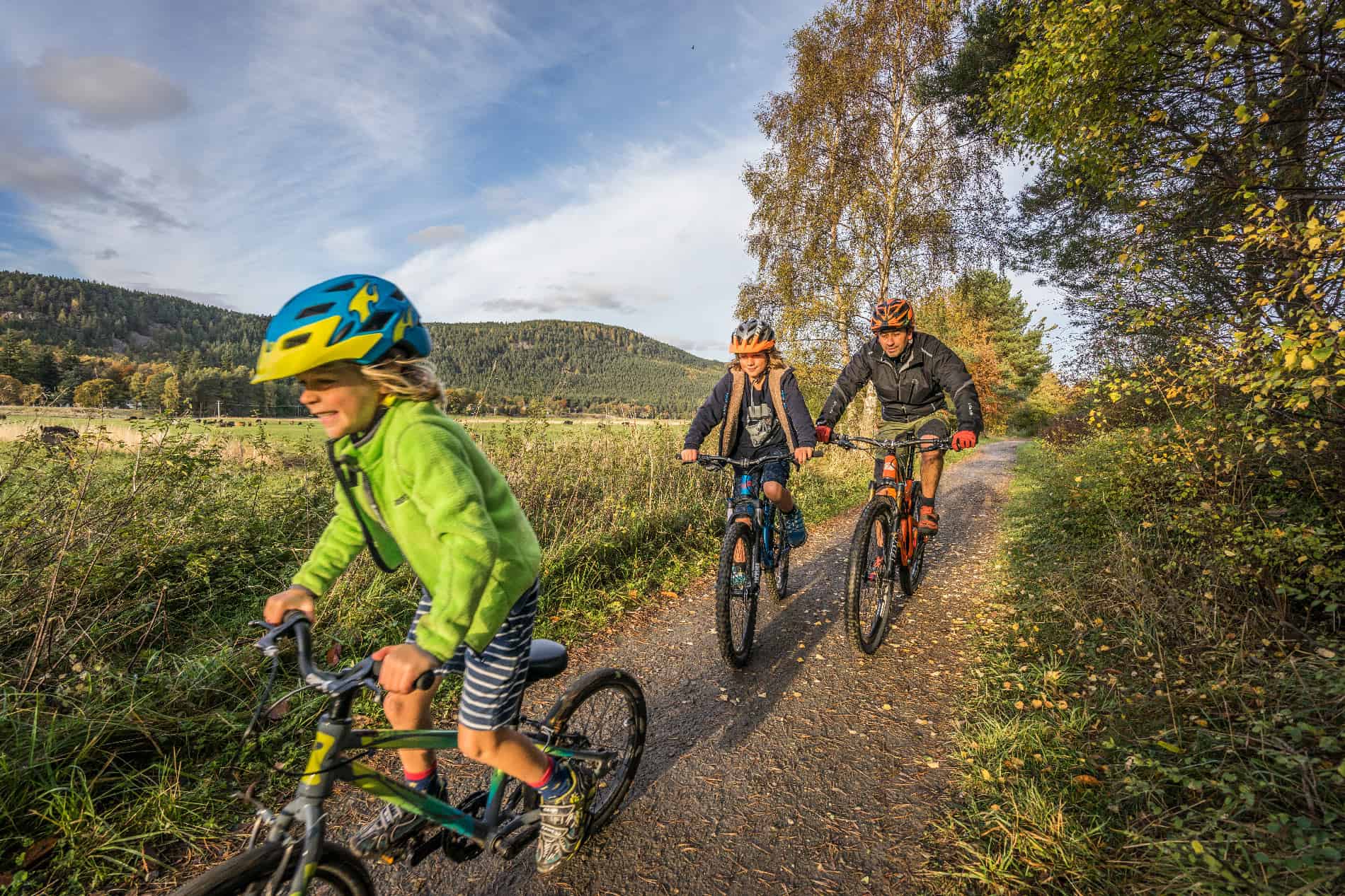 Cyclists enjoying a scenic ride on a trail in the Scottish Highlands.