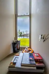 Bright windowsill with books, owl ornament, and view of Highland landscape.