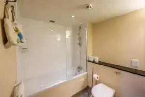 Bathroom with bathtub and shower, featuring modern fixtures and clean design at Highland Club Scotla.