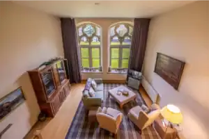 Cozy Highland Club living room with large windows and classic furnishings.