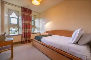 Cozy bedroom at Highland Club Scotland with classic decor and natural light.