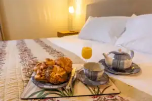 Breakfast tray with croissants, tea, and orange juice in a Highland Club Scotland bedroom.