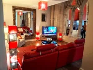 Modern living room with red sofas and decorative lighting at Highland Club Scotland.