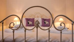 Elegant bedroom featuring a vintage-style metal bed frame and cozy reindeer cushions.