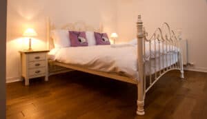 Luxury bedroom with elegant white iron bed and soft lighting, perfect for relaxing stays at Highland.