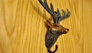 Deer head wall mount with antlers, wooden background, Highland Club Scotland.