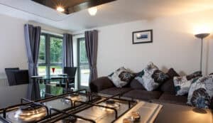 Interior view of Highland Club Scotland with living room, sofa, and kitchen appliances.