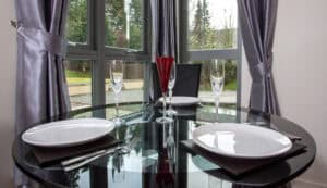 Elegant dining table with glassware and tableware in a bright, modern setting.