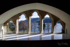 Lake view through historic arches at Highland Club Scotland.