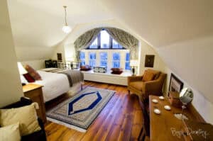 Cozy bedroom with large window and classic decor at Highland Club Scotland.