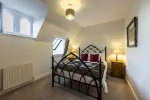 Elegant bedroom with wrought iron bed and warm lighting.