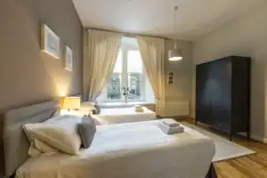 Bright Highland Club bedroom with twin beds, elegant decor, and scenic views of the Scottish landsca.