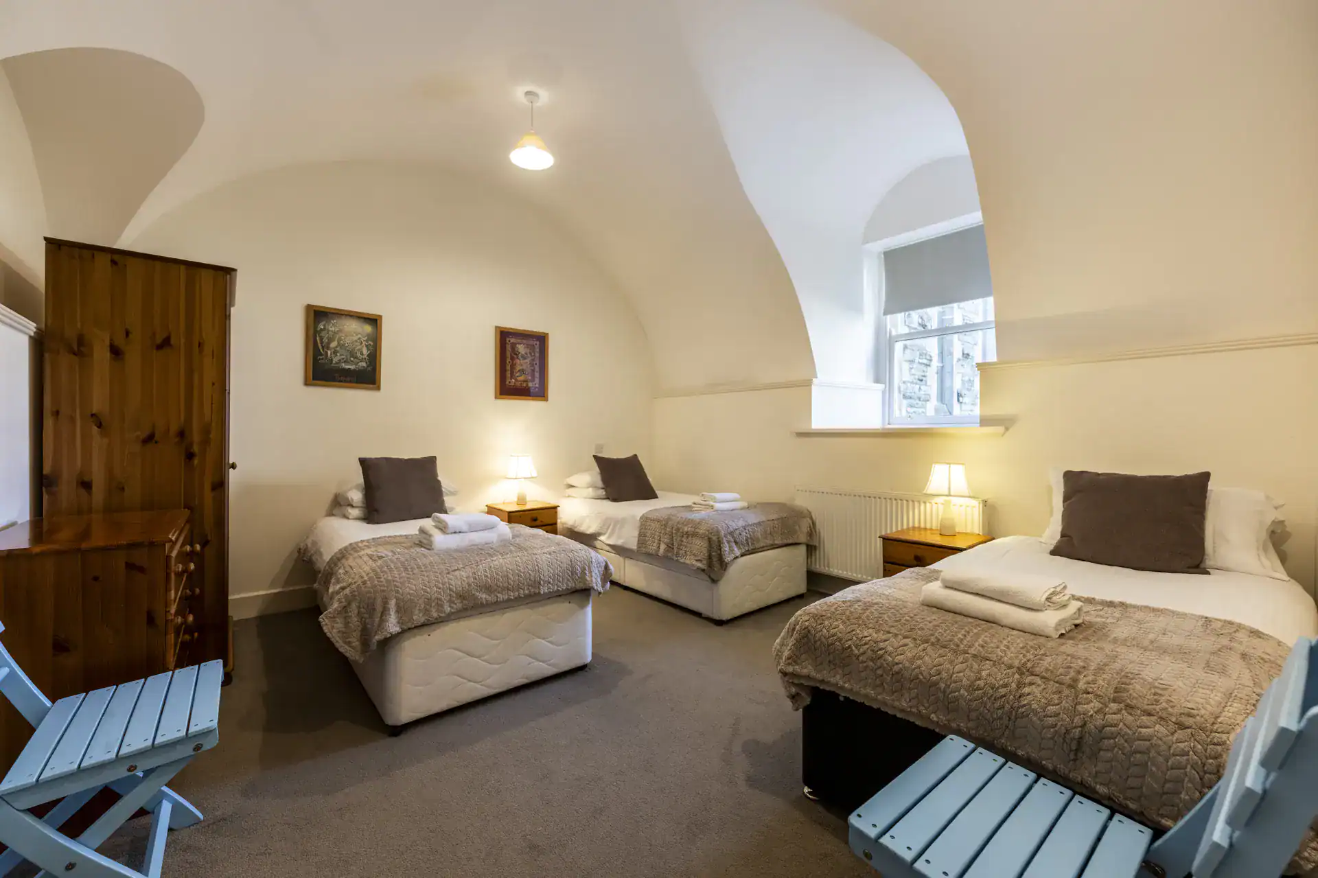 Comfortable Highland Club accommodation with three beds, warm lighting, and Scottish charm.