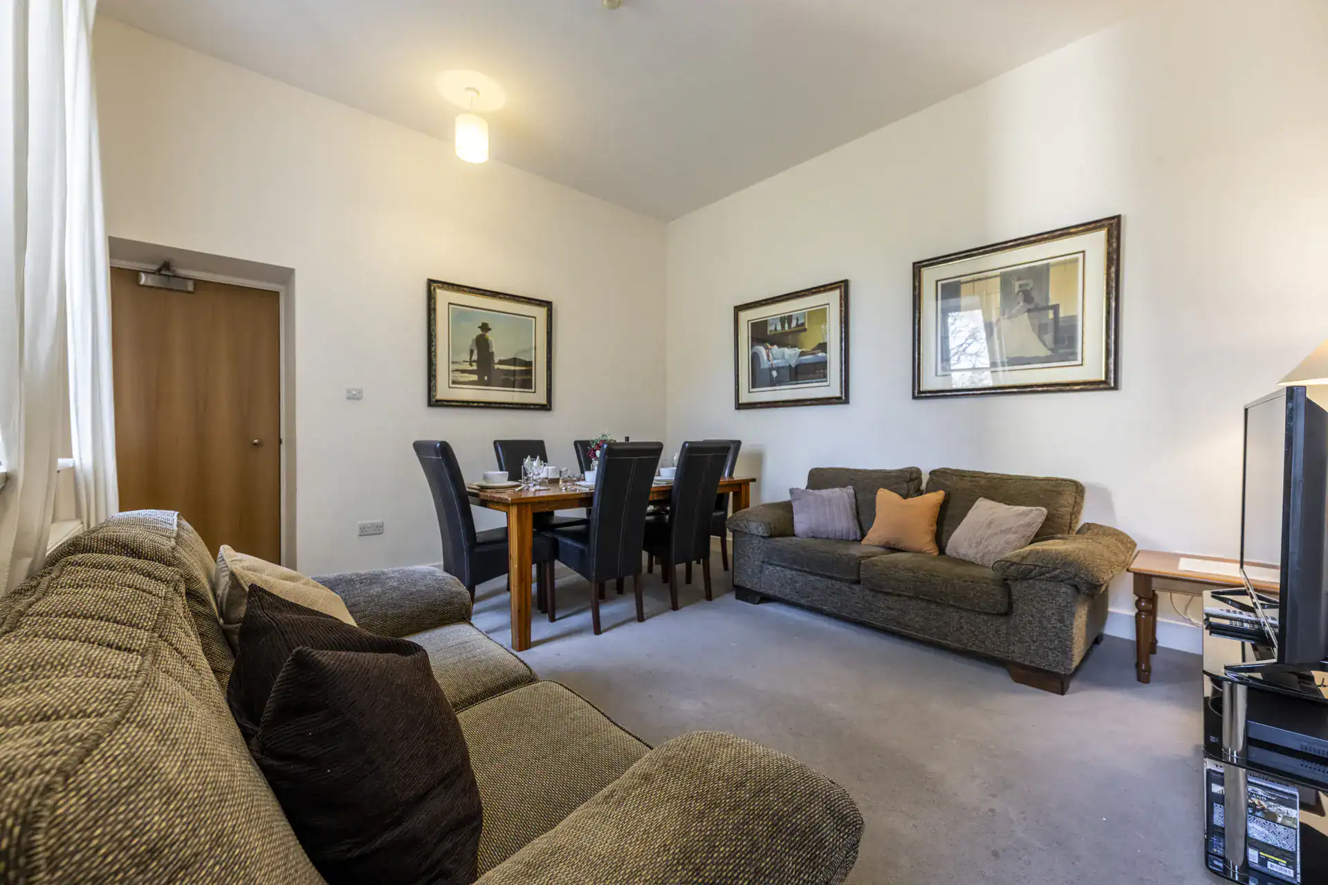 Highland Club Scotland living room with sofas, dining area, and artwork.