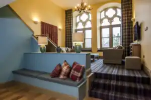 Elegant lounge area at Highland Club with classic decor and large windows.