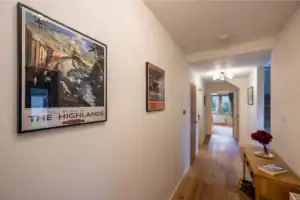 Modern hallway at Highland Club Scotland development with artwork and wooden flooring.