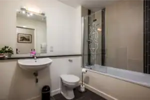 Modern bathroom with bathtub, toilet, and sink at Highland Club Scotland development.