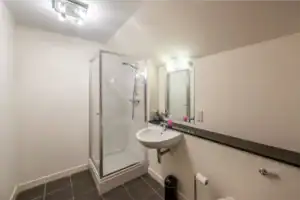 Highland Club Scotland bathroom with shower, sink, and mirror.