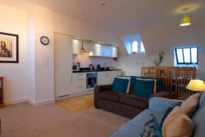 Modern Highland Club apartment living room with open-plan kitchen and comfortable seating.