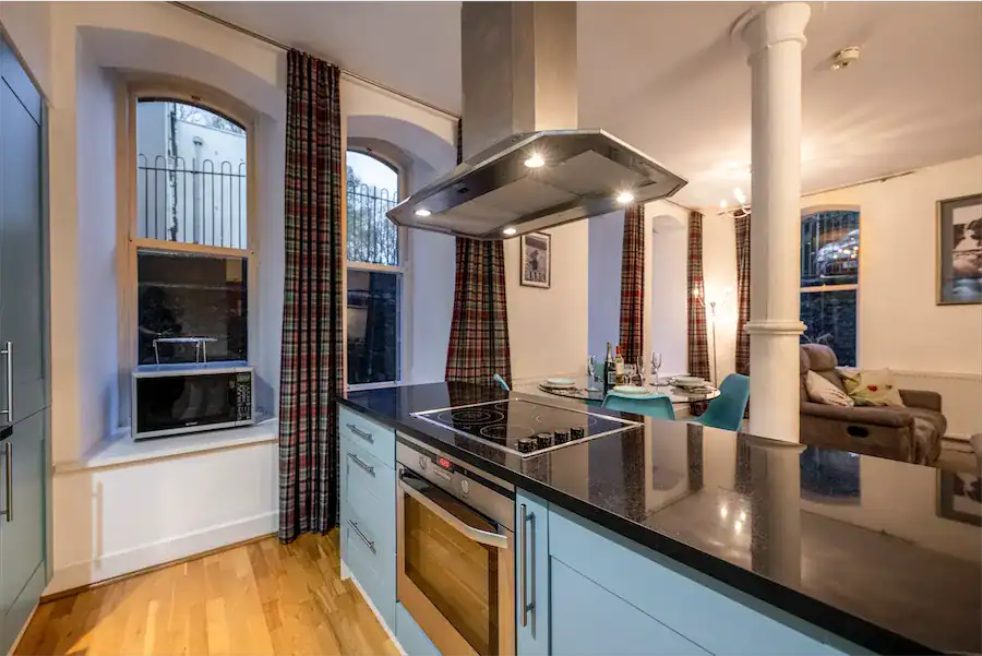 Spacious kitchen area with classic design, large windows, and contemporary appliances.