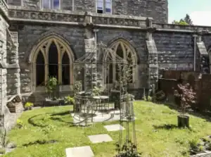 Historic church garden with metal gazebo and lush greenery in Scotland.