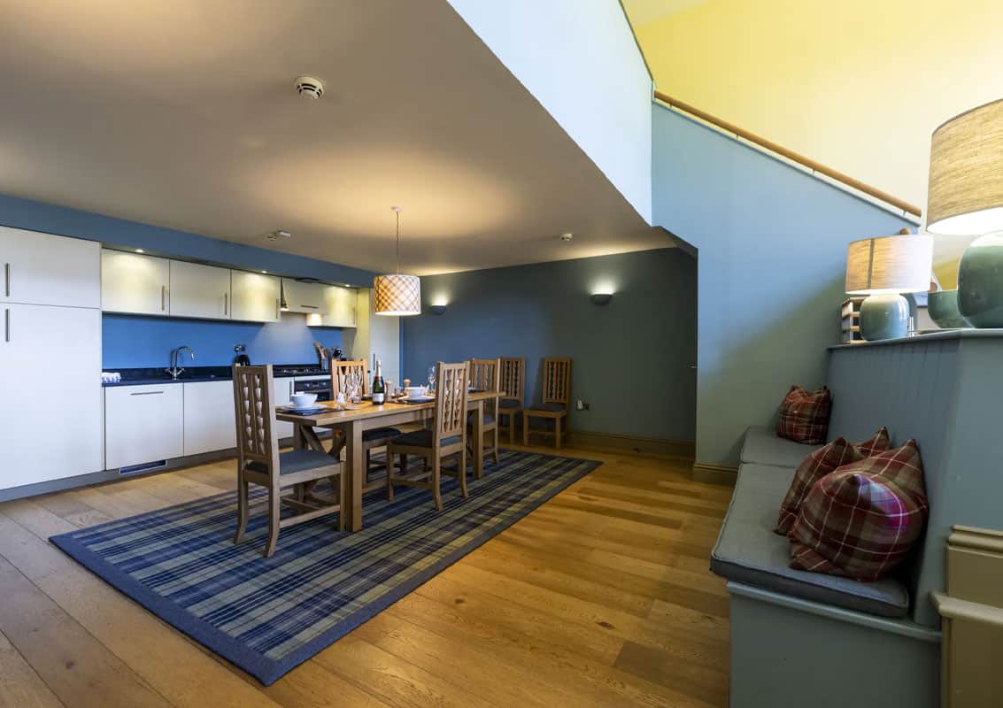 Contemporary dining space with wooden table and chairs in Highland Club Scotland.