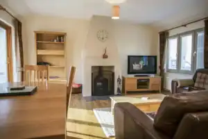 Bright Highland Club living room with fireplace and modern TV.
