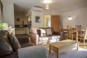 Spacious Highland Club living room with comfortable sofas and dining area.