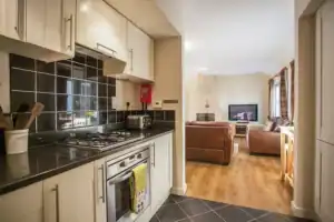 Bright and inviting living space at Highland Club Scotland. Modern kitchen leading into a comfortabl.