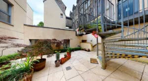 Courtyard area at Highland Club Scotland with potted plants and outdoor staircase.