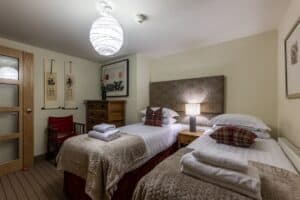 Comfortable Highland Club guest room with twin beds and traditional decor.