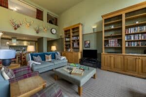 A welcoming Highland Club lounge featuring comfortable seating, bookshelves, and decorative accents.