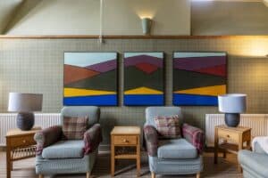 Highland Club Scotland lounge with vibrant abstract artwork and comfortable seating.