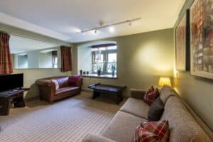 Living room at Highland Club Scotland with comfortable sofas and scenic window views.