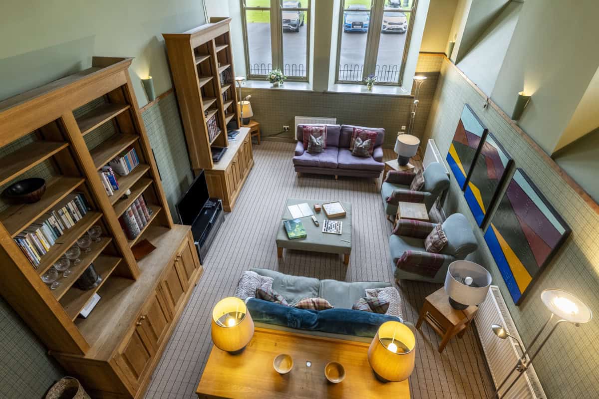 Highland Club lounge with cozy sofas, bookshelves, and large windows.