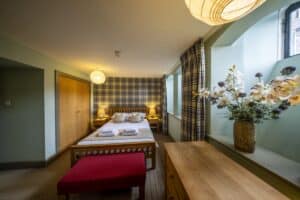 Scenic Highland Club bedroom featuring a large window with views of the Scottish landscape, cosy dec.