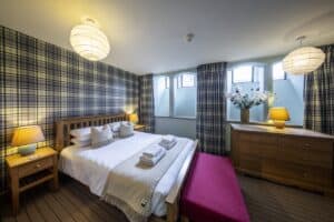 Bright Highland Club bedroom with tartan decor and modern amenities.