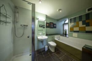 Highland Club Scotland bathroom featuring a walk-in shower, bathtub, and contemporary decor.